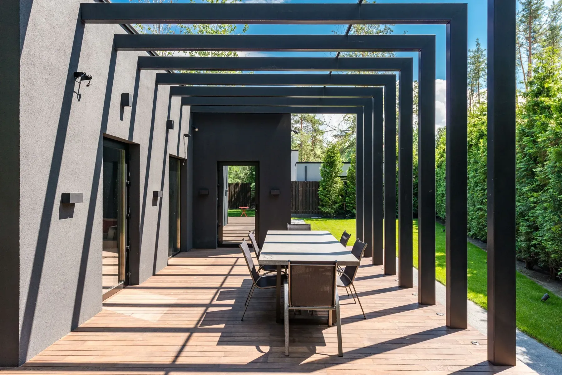 Terasta alüminyum pergola ile gölgelendirilmiş oturma alanı